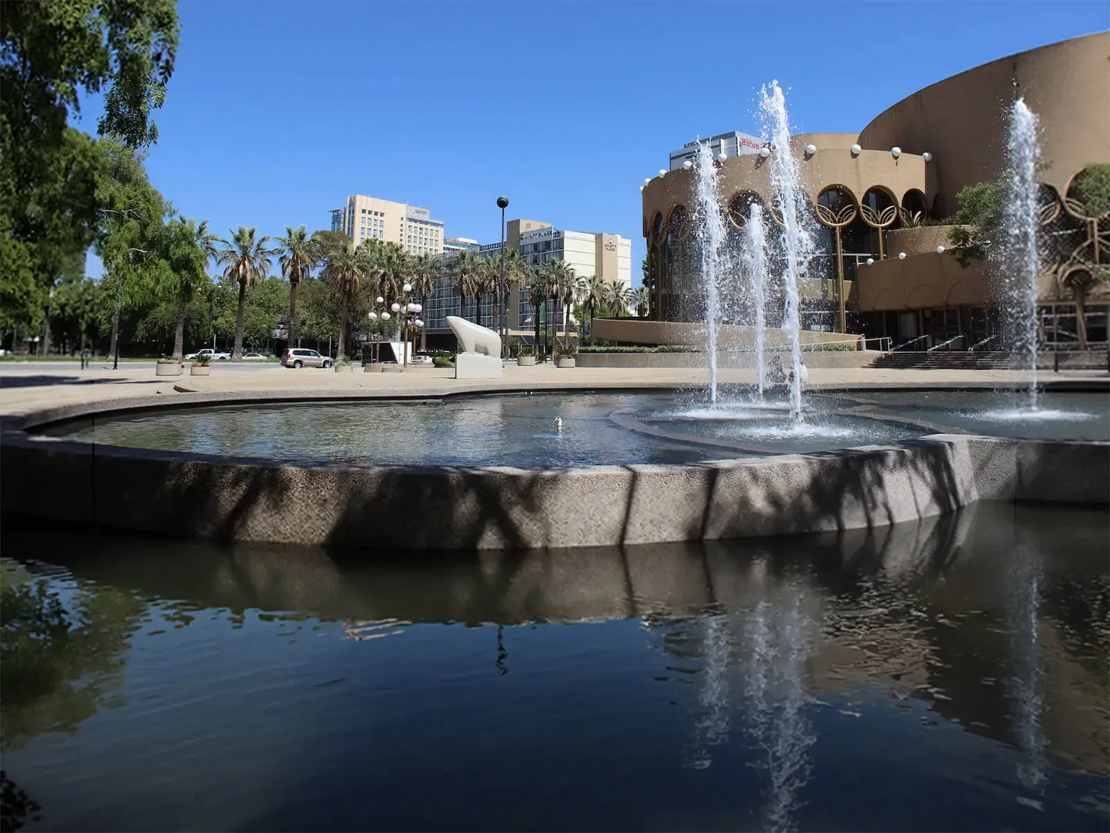 San Jose Catering Company — full-service catering at downtown venues like the San Jose Center for the Performing Arts, with on-site staff, setup, chef-attended service and cleanup in San Jose, Santa Clara, Sunnyvale, Campbell, Cupertino and Los Gatos Plaza fountain in front of the San Jose Center for the Performing Arts with palm trees and the downtown San Jose skyline behind it — the South Bay city San Jose Catering Company serves with full-service wedding and corporate catering