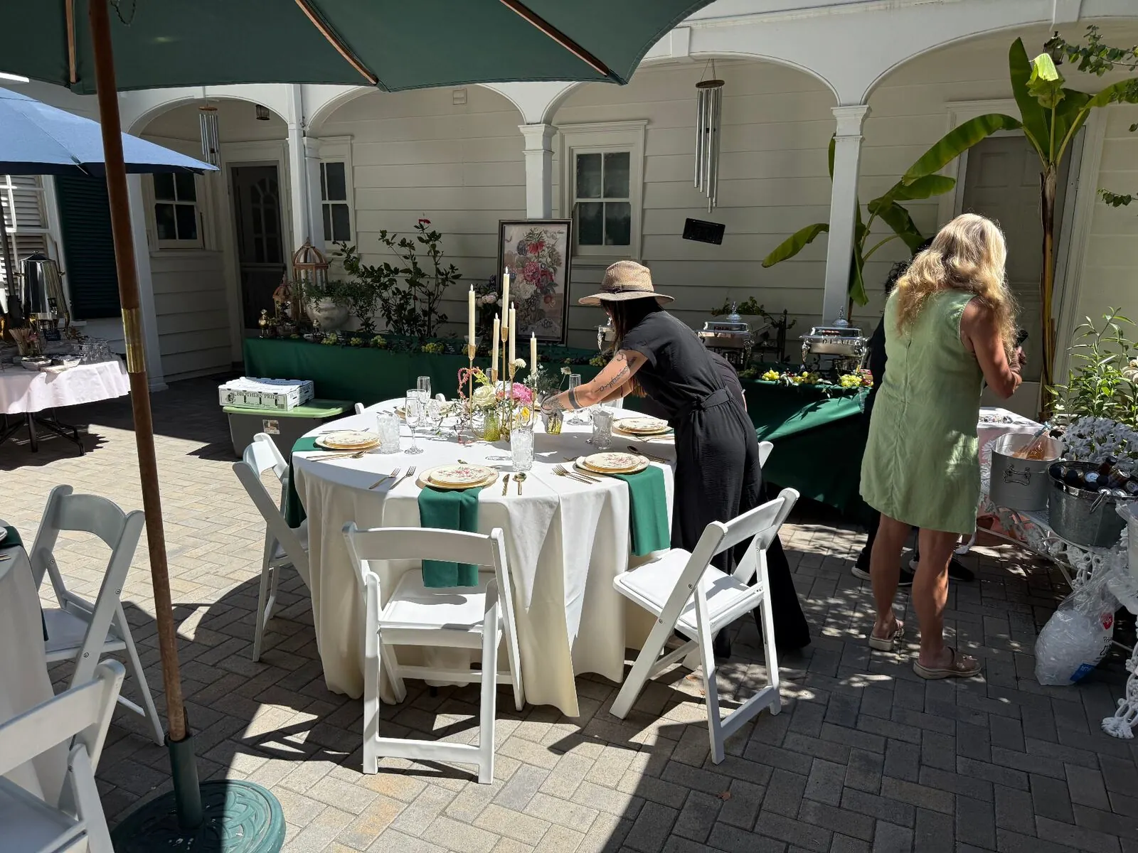 Courtyard tables dressed in emerald linens with upgraded rentals and full place settings — elevated tablescape rentals for Tracy catering