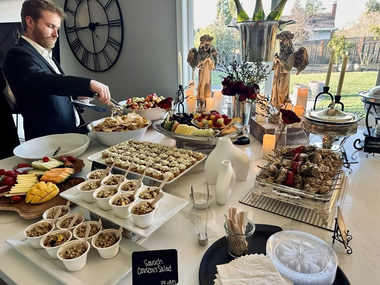 Elegant buffet with couscous salad, fruit platter, and skewers by Tracy Catering Company